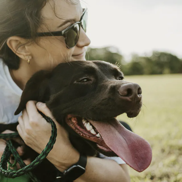 A woman hugging her dog close